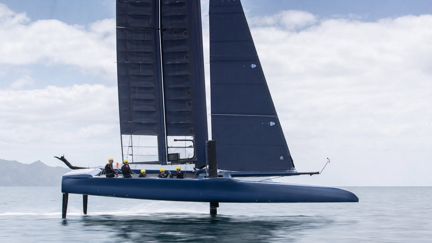 A foiling sailboat under way, hull clear of the water