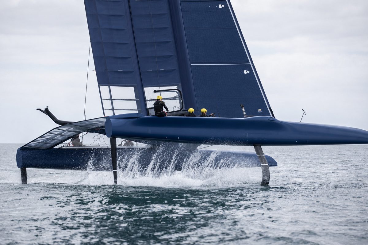A foiling sailboat with its hull lifted clear of the water