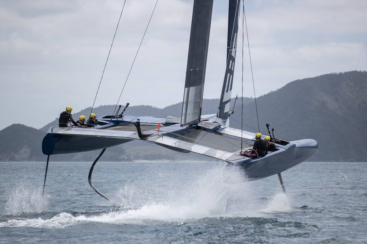 A foiling sailboat lifting onto its foils